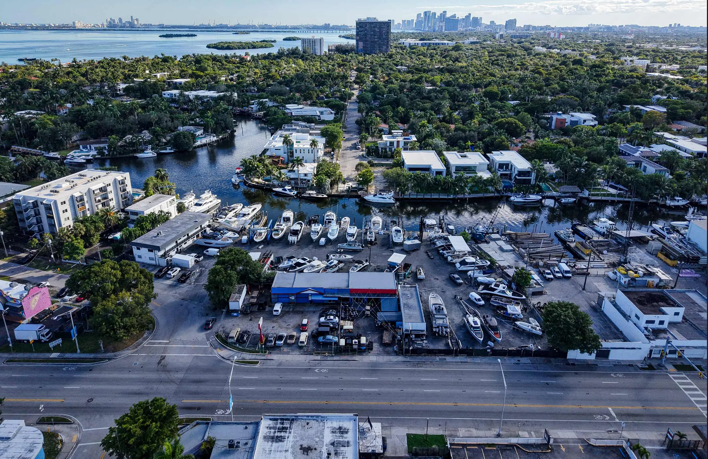Aerial view of 830 NE 79th Street in Miami, with the canal and the Miami skyline in the background.